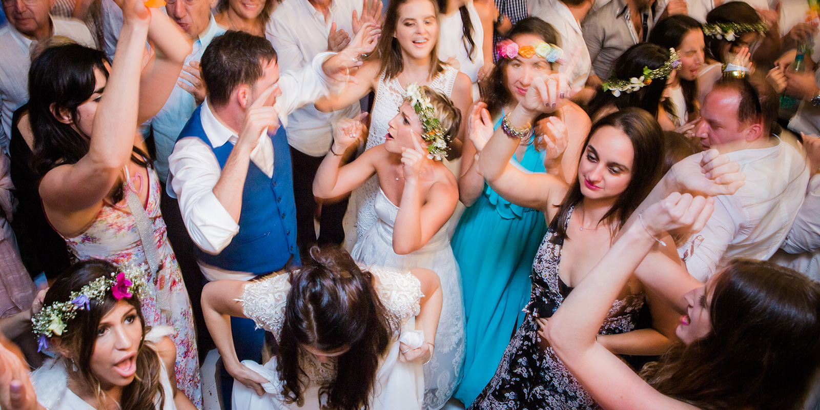 Wedding guests and the bride dancing together on a packed dance floor